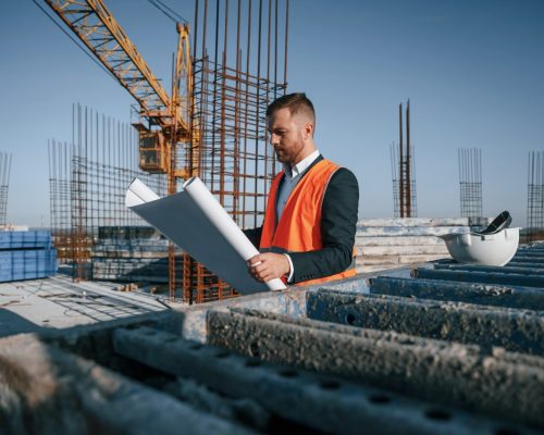 reading-the-plan-man-is-working-on-the-construction-site-at-daytime