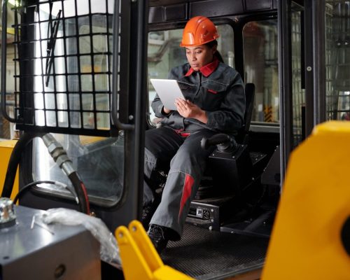 young-busy-worker-of-factory-scrolling-in-tablet-in-construction-machine